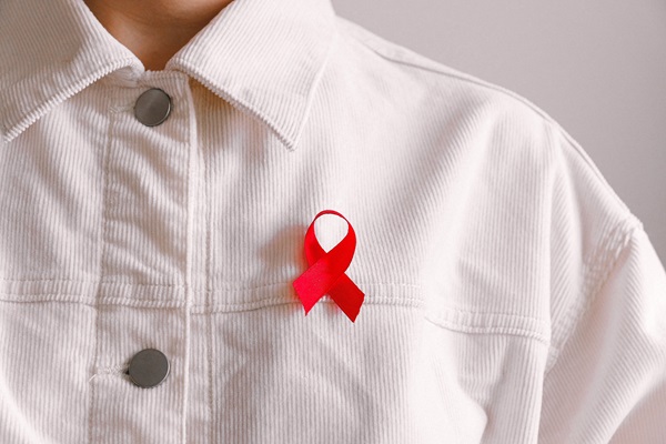 A person with a red ribbon on their chest.