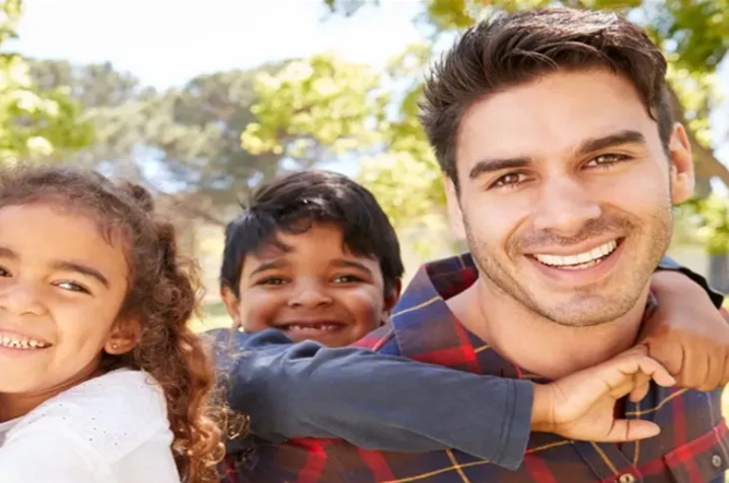 A man and two children smiling for the camera.