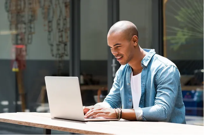 A man sitting at a table with a laptop.